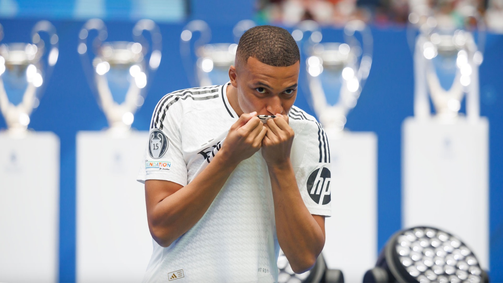 Mbappe hôn lên logo Real Madrid trong lễ ra mắt tại sân Bernabeu ngày 16/7. Ảnh: AFP